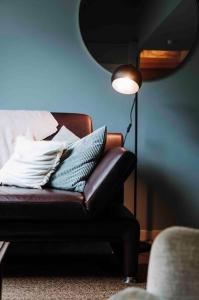 列日L’écrin vintage - Hors Château & Marches de Bueren的棕色皮椅,配有枕头和灯