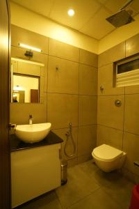 古鲁瓦尤尔SREENARAYANA TOURIST HOME的一间带水槽、卫生间和镜子的浴室