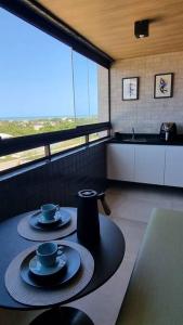 康德Cobertura Vista Mar Carapibus - Cariri Praia - Apartamento completo com 02 quartos的厨房里设有桌子,上面有2杯