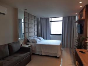 萨尔瓦多OITO ZERO UM - Flat Sol Victoria Marina的酒店客房,配有床和沙发