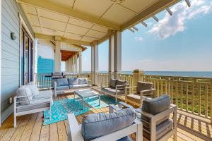 阿兰瑟斯港SBSL706 Luxury, Ocean front beach house, Hot Tub, Boardwalk to Beach的一个带椅子和桌子的门廊和大海