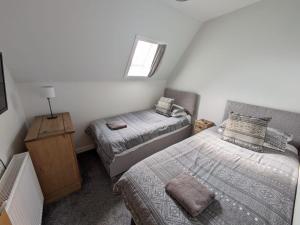 威克2 Bedroom Townhouse on NC500, Wick, Highland的一间小卧室,配有两张床和窗户