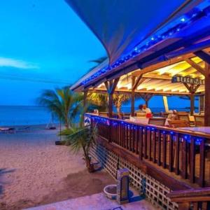 桑迪湾Blue Bahia Resort的海滩上的餐馆,晚上和大海一起用餐