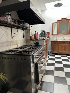 圣安东尼奥德阿雷科Hostel El Puesto的带炉灶的厨房和 ⁇ 格地板