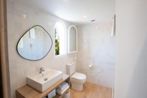 圣马迪拉莫Hôtel Casa Marina的一间带水槽、卫生间和镜子的浴室
