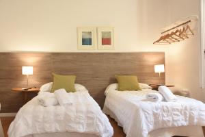 巴塞罗那Ally's Bed&Breakfast,的一间卧室配有两张带毛巾的床