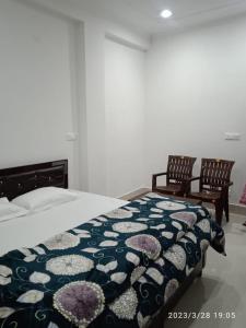 达兰萨拉RADHA BNB ( HOMESTAY )的一间卧室配有一张床和两把椅子