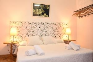巴塞罗那Ally's Bed&Breakfast,的一间卧室配有一张带两盏灯的大型白色床。