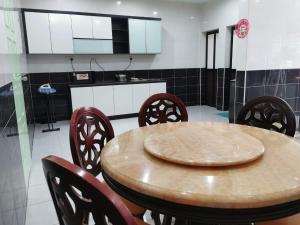马西JMKT Homestay @ Bandar Seri Alam的厨房配有木桌和椅子