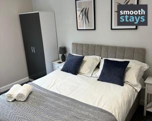 普雷斯顿Modern 2 Bed Apartment By Smooth Stays Short Lets & Serviced Accommodation Preston With Parking Near Train Station的一间卧室配有一张带蓝色和白色枕头的床