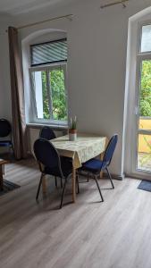 柏林哈伯特斯膳食公寓的一间带桌椅和2扇窗户的用餐室