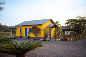 Volta GrandePousada Nonno Fiorindo的蓝色屋顶和庭院的黄色房子