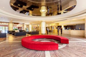 阿德耶蓝花楹最佳酒店的中间有一个红色圆圈的大型大堂