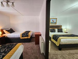 威廉斯港Hotel Forjadores del Cabo de Hornos的酒店客房,设有两张床和镜子