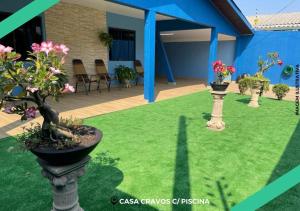 伊瓜苏CASA CRAVOS C/ PISCINA的花园内有两个花瓶,里面花朵