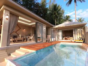 蔻立Devasom Khao Lak Beach Resort & Villas的一座带游泳池和庭院的房子