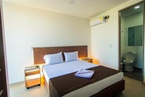 阿卡西亚斯HOTEL EL NARANJO的一间卧室配有一张大床、床头柜和一张四柱床
