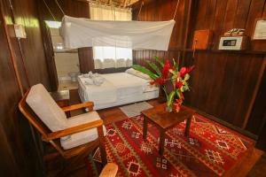 马尔多纳多港Sandoval Lake Lodge的卧室配有1张床、1张桌子和1把椅子