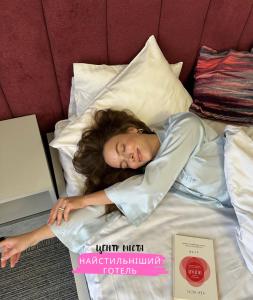 敖德萨德利巴斯酒店的女人躺在床上,头戴在枕头上
