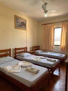 圣若昂达博阿维斯塔Hotel Bandeirantes de SJBV的客房设有三张床和吊扇。
