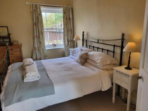 费克纳姆Highfield Farm的卧室配有一张大白色床和窗户
