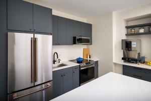 新布法罗The Neighborhood Hotel New Buffalo的厨房配有黑色橱柜和不锈钢冰箱