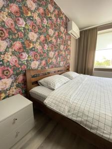 LiskiMini Hotel的一间卧室配有一张带花卉壁纸的床