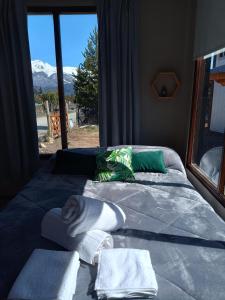 圣卡洛斯-德巴里洛切Tiny house Bariloche的一间卧室配有带毛巾的床和窗户。