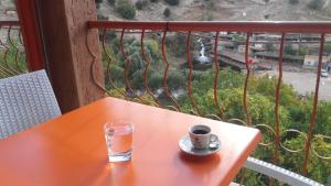 Kasba des Aït MoussaGite Rahhaoui Simo的阳台上的橙色桌子,上面放着一杯和一杯