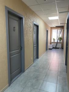 LiskiMini Hotel的空的走廊,有两扇门,铺着瓷砖地板