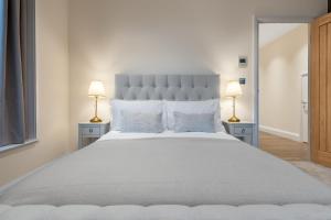 特威克纳姆Candler Mews的一间卧室配有一张带两盏灯的大型白色床。