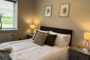 Silver Stag Properties, 3 BR Sandstone Lodge的一间卧室配有带白色床单和枕头的床。