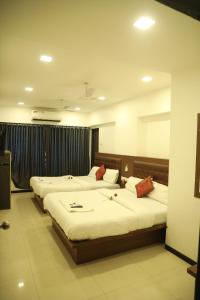 孟买Hotel Shiv Leela Grand的一间酒店客房,房间内设有三张床