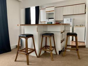 圣赫利尔泽西Sarum Apart-Hotel的厨房配有2张吧台凳和1个柜台。