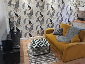 博古舒夫-戈尔采Apartament "Konie i anioły"的客厅配有黄色沙发和壁纸