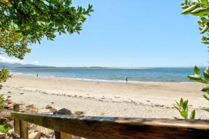 蒂拉穆克Terimore Lodging by the Sea的海滩上的长凳,背景是大海