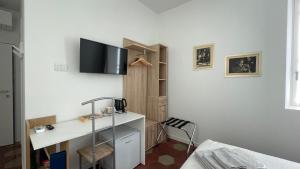 洛韦雷Santa Vincenza - Suite Indipendente的客房设有书桌和墙上的电视。