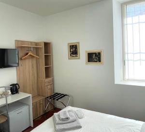 洛韦雷Santa Vincenza - Suite Indipendente的一间卧室设有一张床、一台电视和一个窗口。