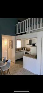 圣马迪拉莫Appartement de standing avec terrasse的厨房配有白色橱柜和桌椅