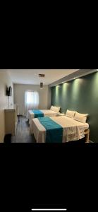 La BarcaHotel Real Briseñas的卧室设有两张床铺和绿色的墙壁
