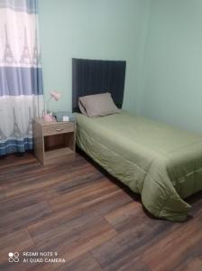 阿雷基帕DEPARTAMENTO EN YANAHUARA 3er piso的一间卧室配有一张床和一个带床罩的床头柜。