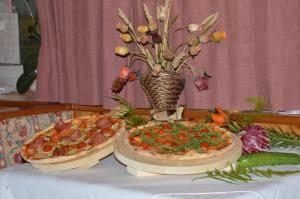 利维纳隆戈德尔科Hotel Garni Excelsior的桌上的两块比萨饼,花瓶