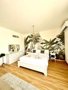 迪拜Casa Soraya的卧室配有白色的床和棕榈树壁画