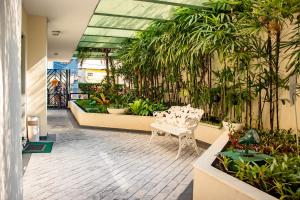 圣保罗日内瓦公寓式酒店的里面有一个温室,里面种有植物,有白色的椅子