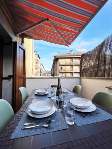 普奇塞达Casa Baronia La Cerdanya的一张带盘子和玻璃杯的桌子和一瓶葡萄酒