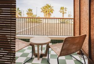 瓦伦西亚Casa Bassa的阳台配有桌椅和棕榈树。