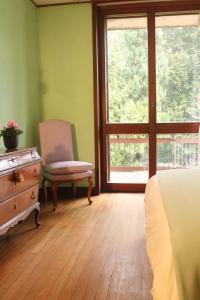 OggionoVilla Inella的卧室配有床、椅子和窗户。