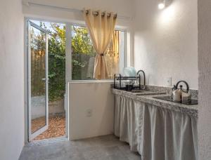 阿拉亚尔达茹达Charm Bahia Suites的厨房设有水槽和窗户。