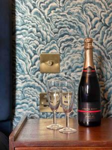 KentThe Bedford Inn的一瓶香槟和一张桌子上的两杯酒