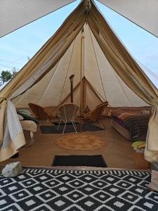 LabroyeAu Pied Du Trieu, the glamping experience的一个带床和椅子的帐篷